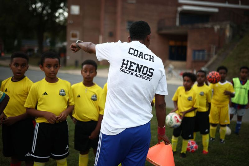 Coach Awet directing a line of players in Henos jerseys