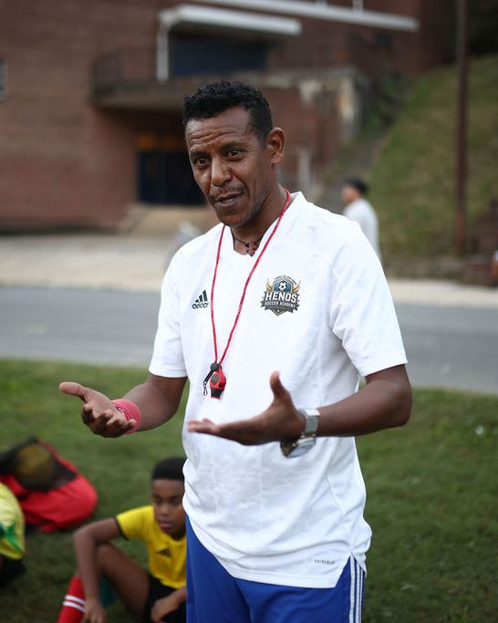 Coach Awet Berhane talking with his players during a session