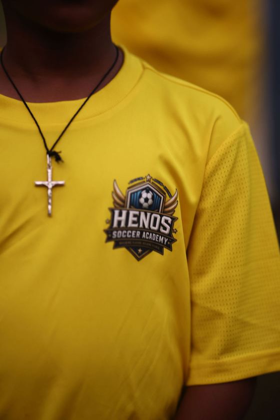 Close up of the Henos Soccer Academy crest on a player's jersey