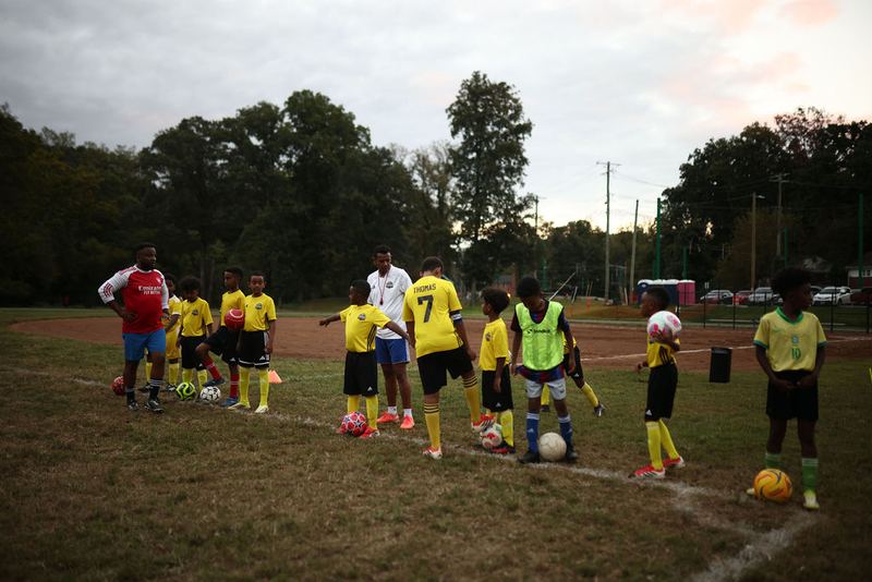 Players lined up across the field for a dribbling drill
