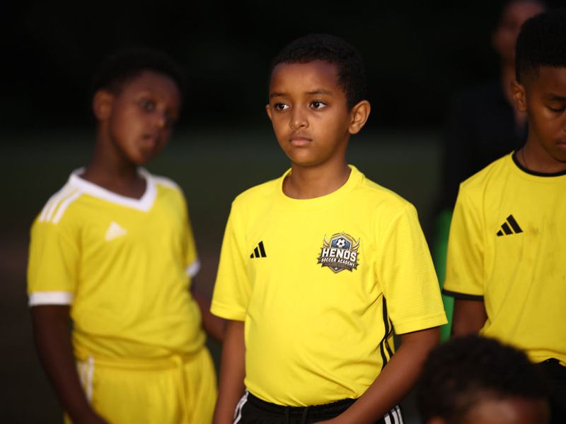 Players in yellow jerseys with the Henos crest